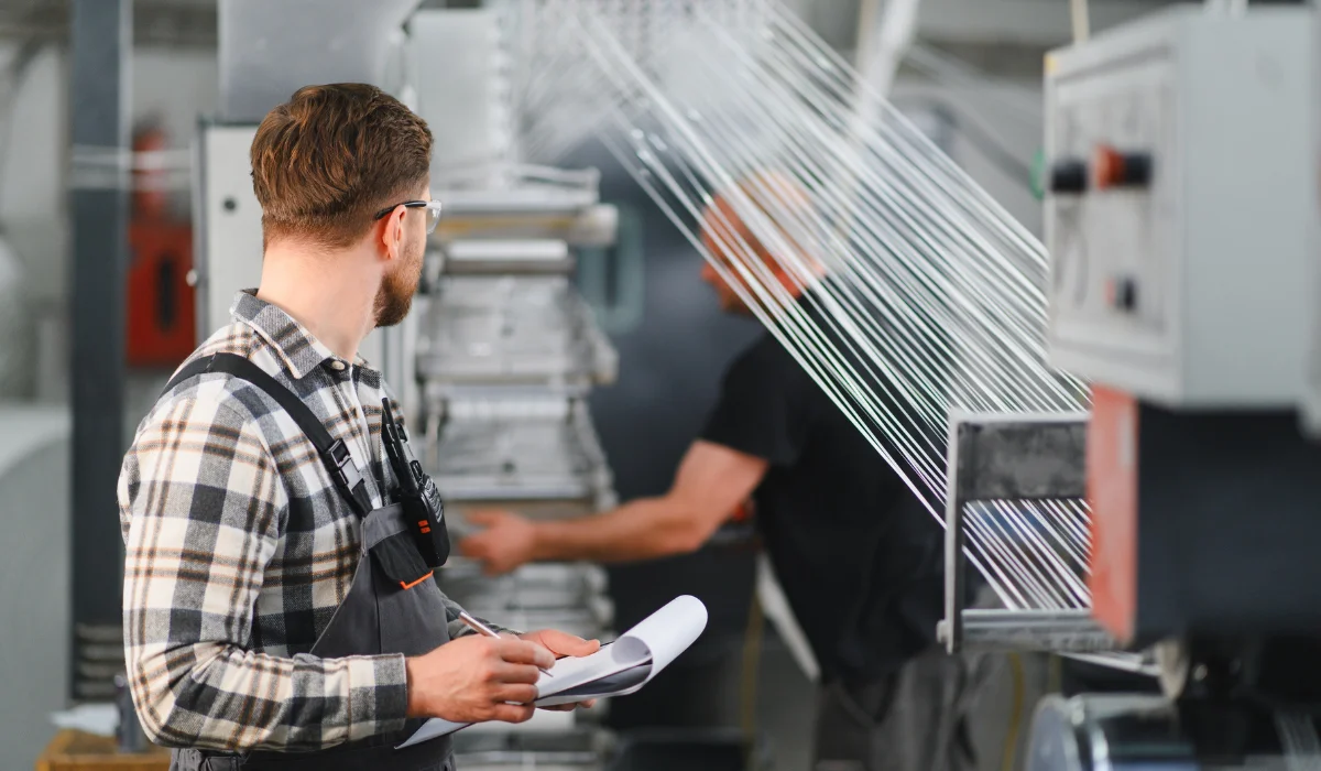 Worker checking production process of polymer threads
